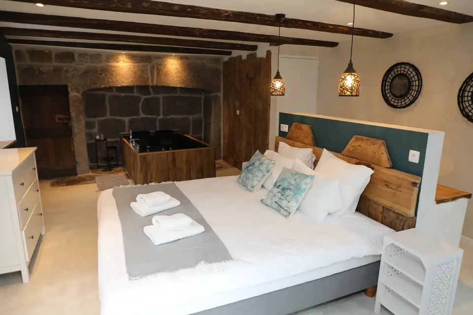 Chambre au lit double ouverte sur la baignoire balnéo
