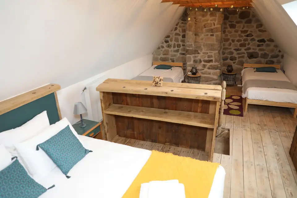 Chambre sous les combles, mur de pierre et poutres apparentes