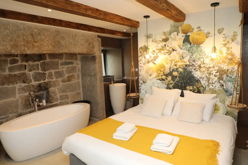 Chambre au papier peint fleuri et baignoire îlot