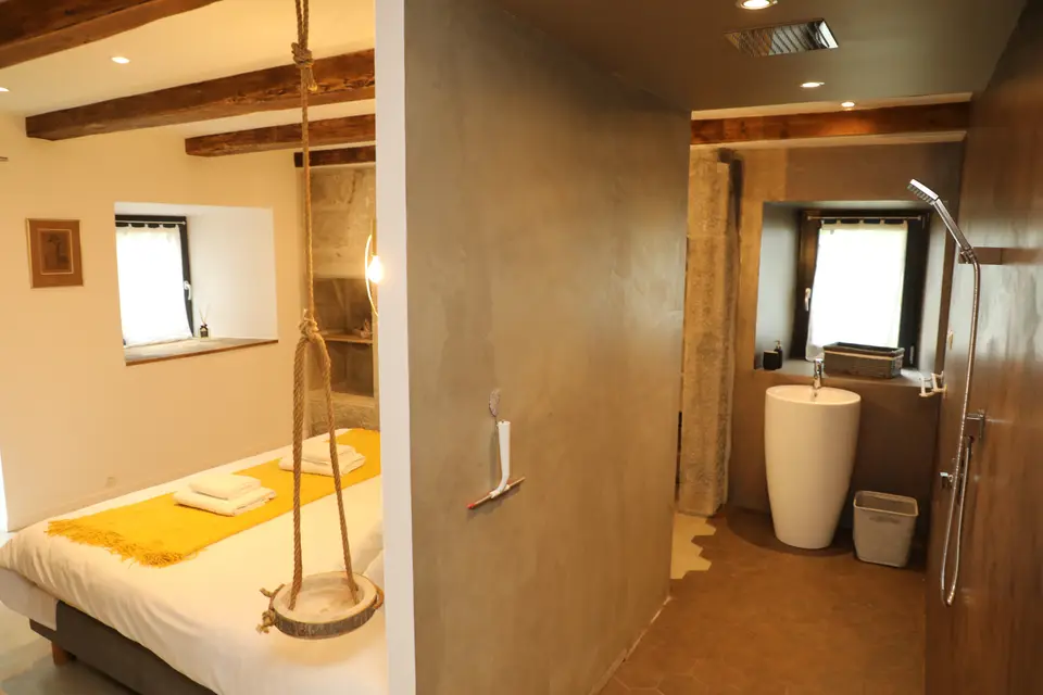 Chambre ouverte sur une salle d'eau avec vasque sur pied