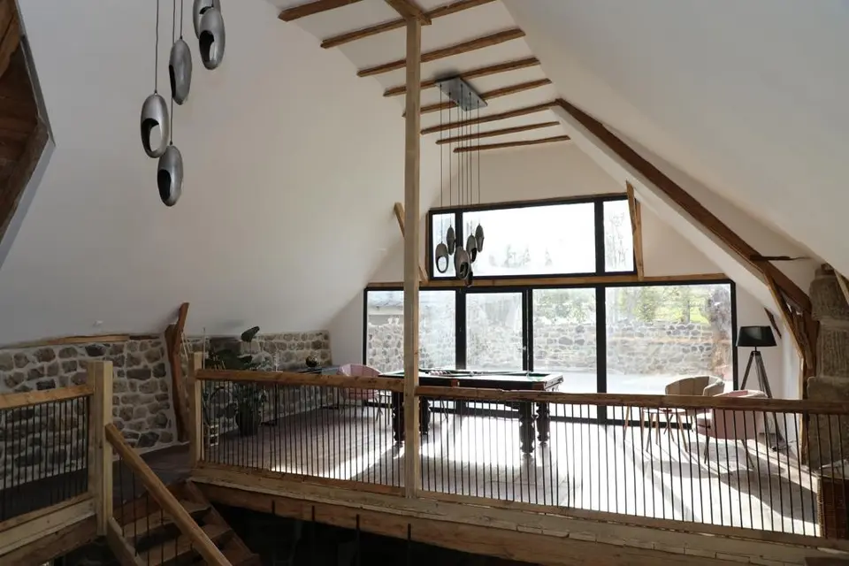 Mezzanine sous la charpente avec grande baie vitrée