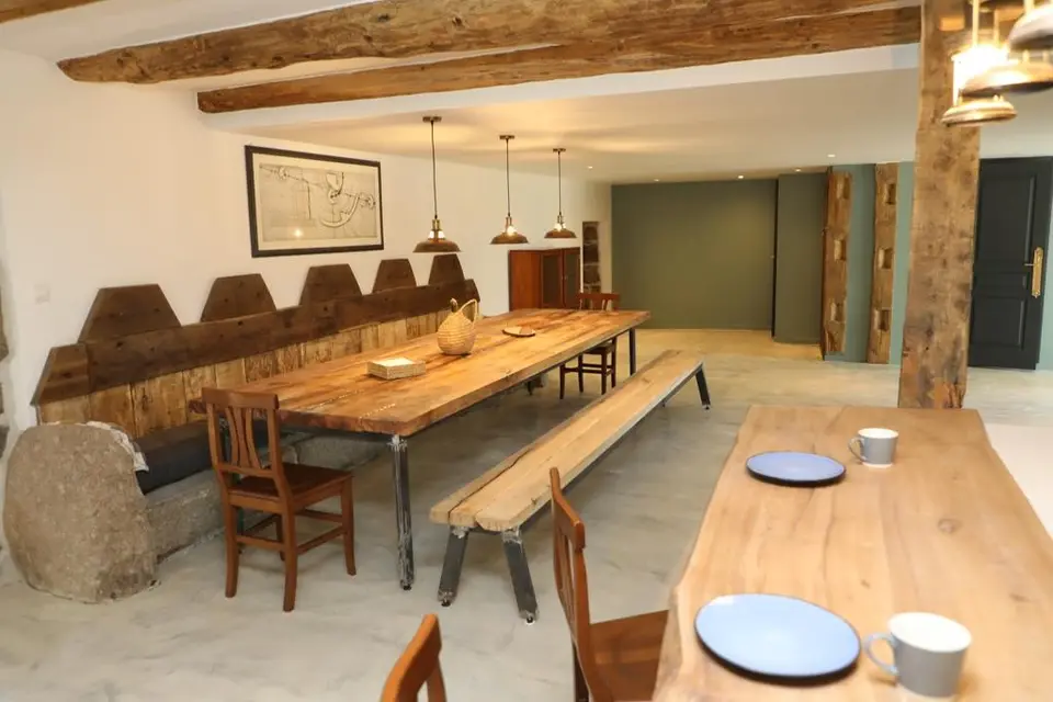 Grande pièce à vivre avec tables et bancs en bois